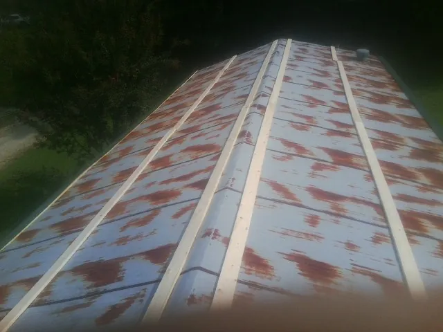 Rusted metal roof panels with new wood purlins before replacement — Storm Damage Roof Repair in Ruffs Dale by Roofing Brothers