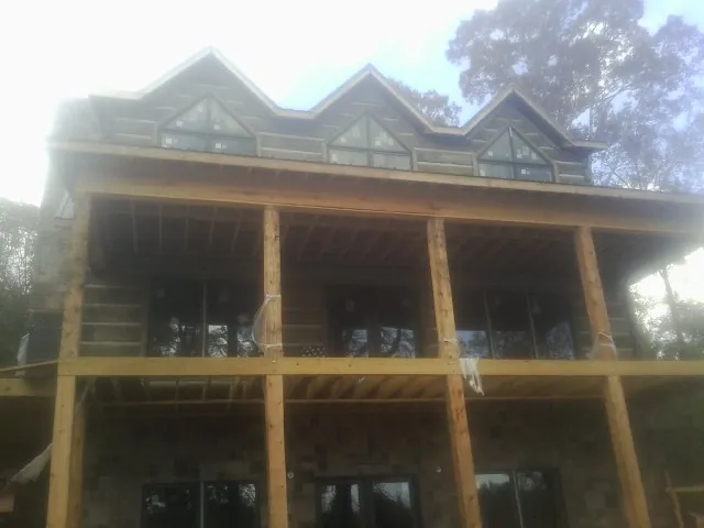 Dormers and porch framing on a large log home under construction — Roof Coating work by our crew in Ruffs Dale