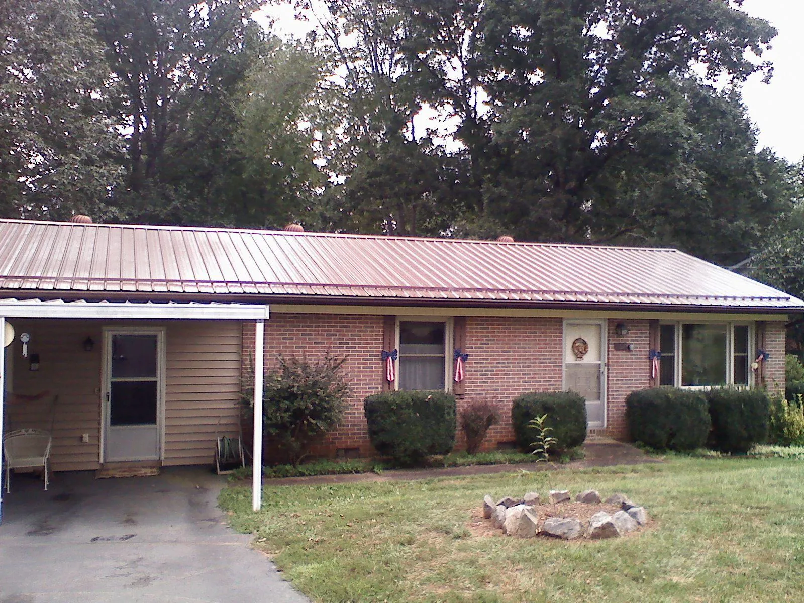 Bronze metal roof and carport on a brick ranch home — Roof Repair work by our crew in Ruffs Dale